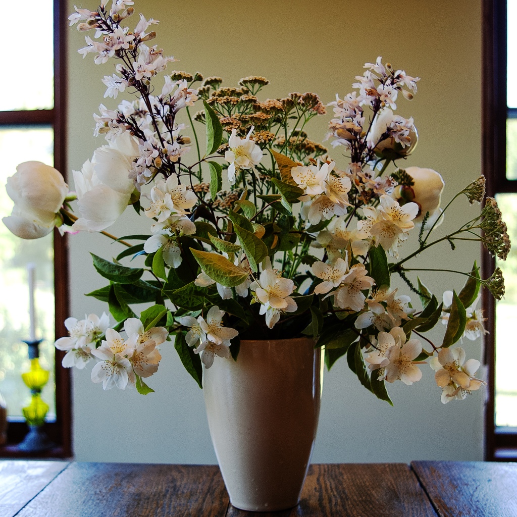 White porcelain vase filled with white flowers.